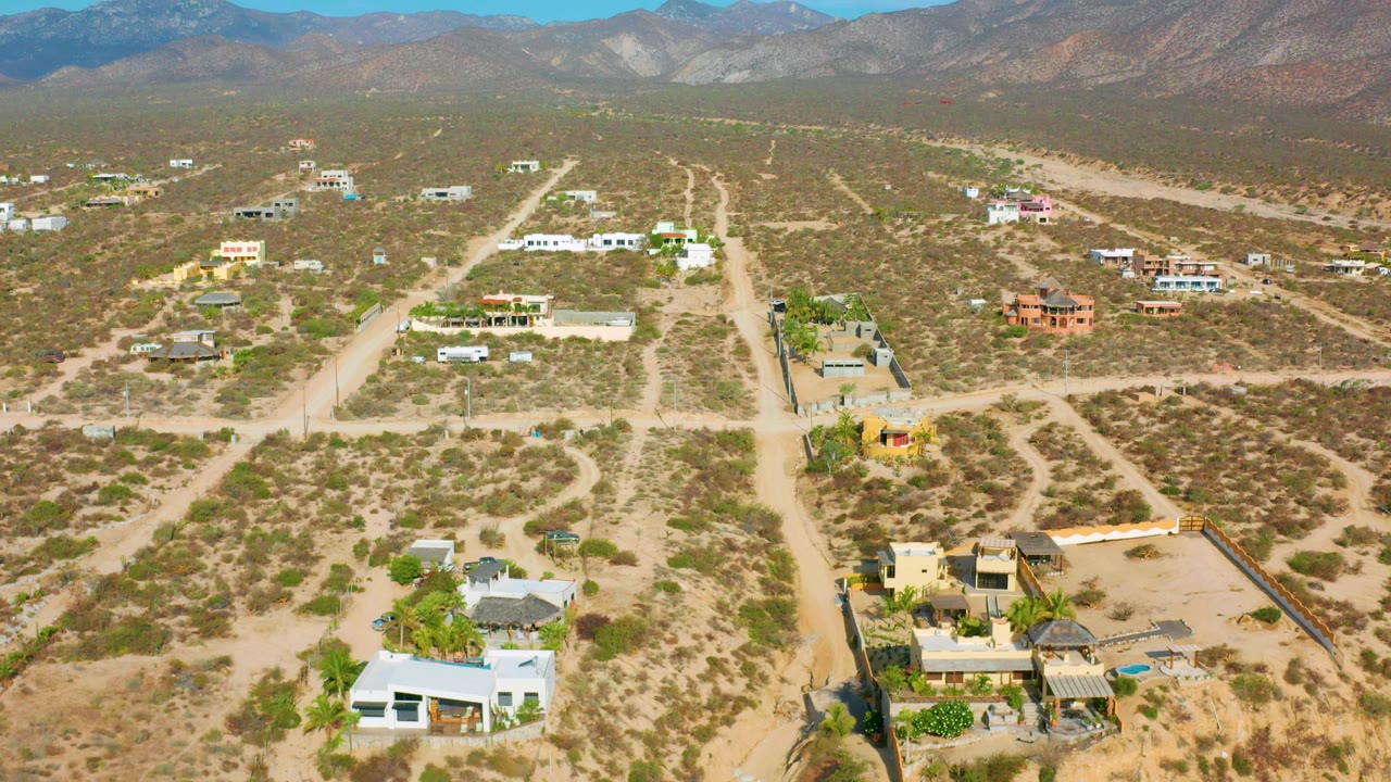 High desert view with homes, scrubland roads, and a mountain horizon.