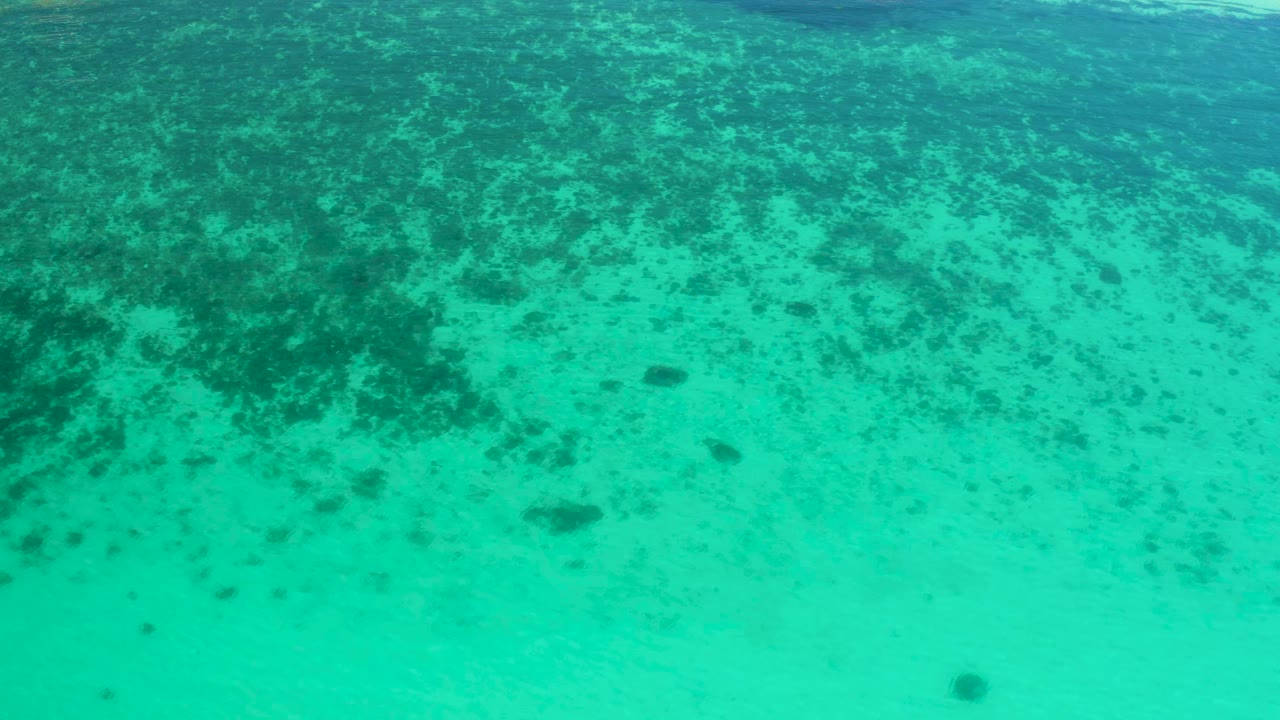 Aqua water in El Sargento La Ventana, Mexico, shows a pale sandy bottom below darker underwater patches, with no visible people.
