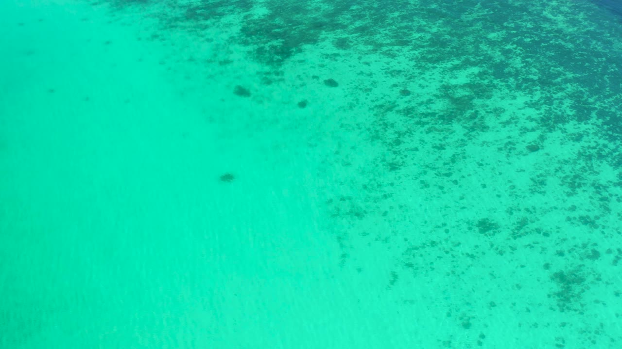 Green-blue coastal water in El Sargento La Ventana, Mexico, seen from above with a broad dark seabed area toward the top right and no visible people.