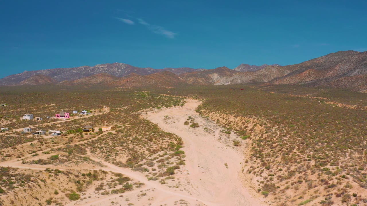 Elevated view over sandy desert terrain and distant mountains