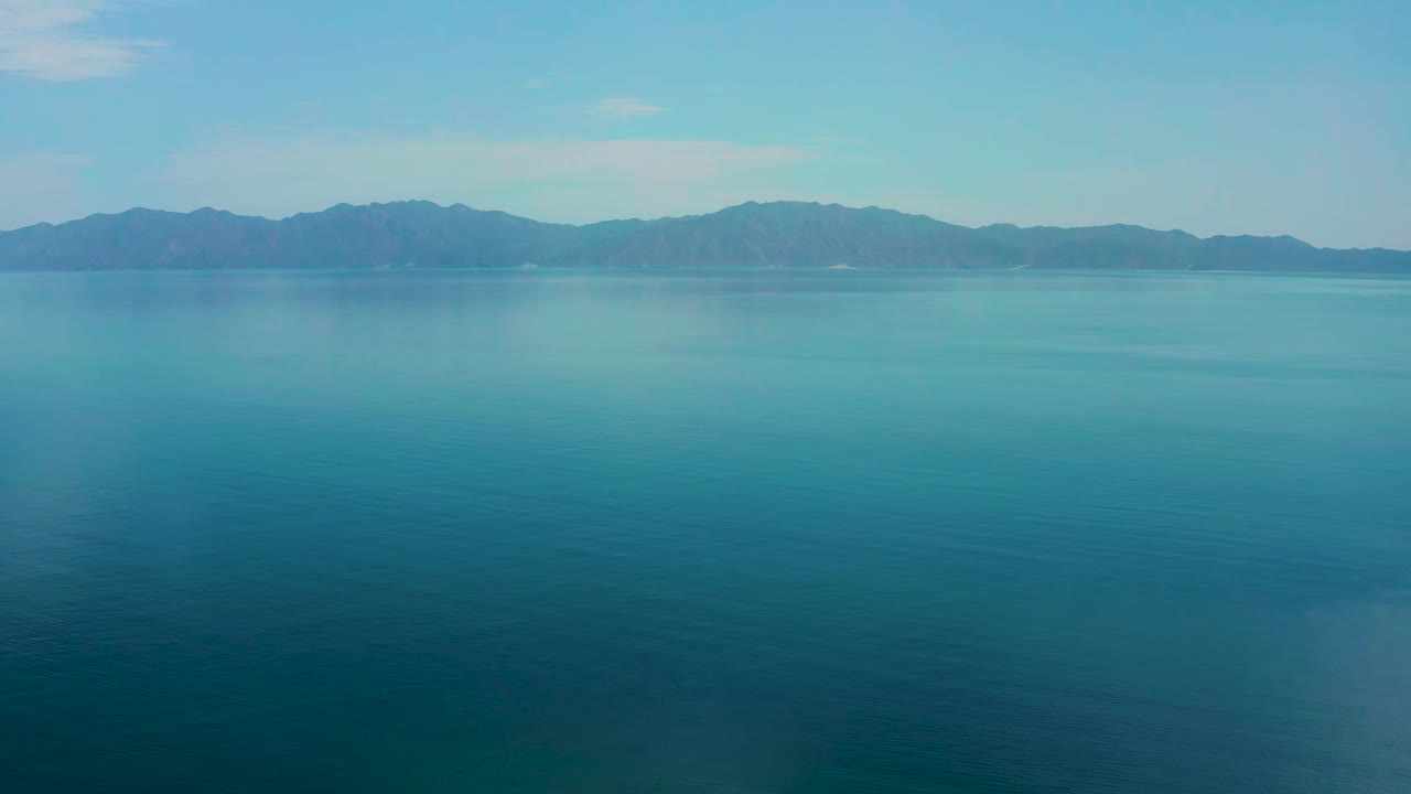 Calm blue sea stretching toward a mountain horizon