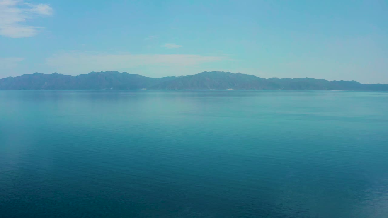 Early frame over El Sargento La Ventana water with the mountain ridge centered across the horizon and no visible people or structures.