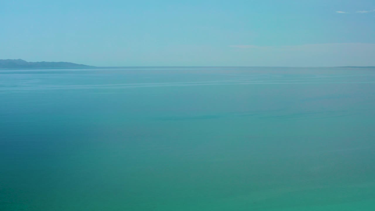 Turquoise sea with distant land on the horizon