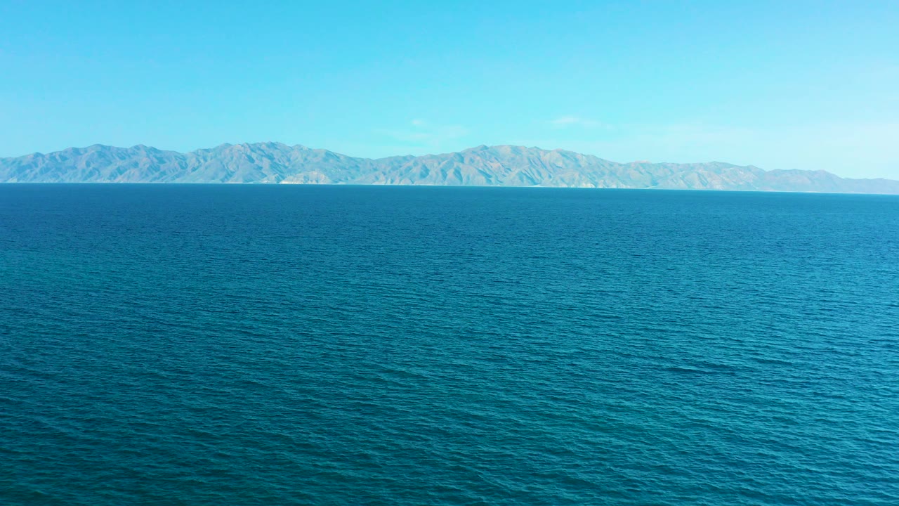 Wide blue ocean view in El Sargento La Ventana, Mexico, with a distant mountain coastline along the horizon and no visible people.