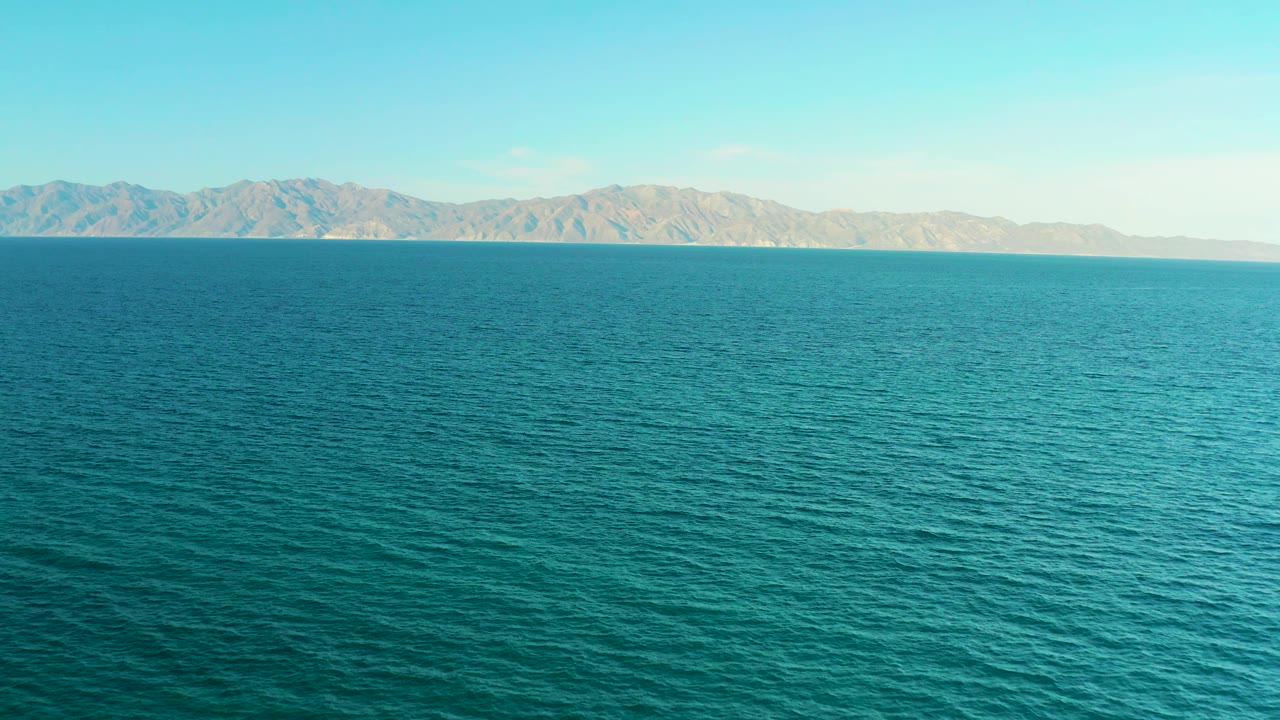Third frame keeps the El Sargento La Ventana ocean view centered, with pale mountains in the distance, bright sky above, and no visible people.