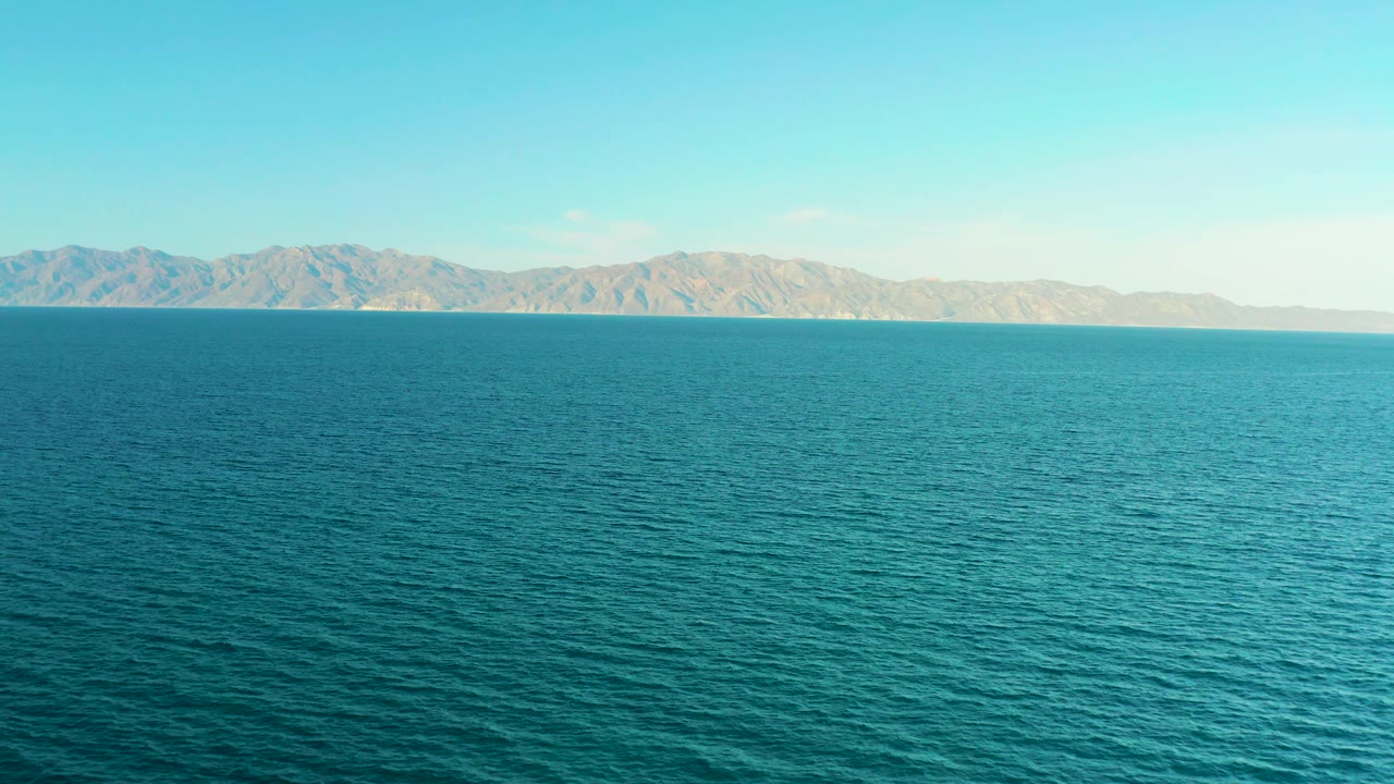 A broad field of blue water runs to distant mountains under clear daylight in El Sargento La Ventana, Mexico, with no visible people.