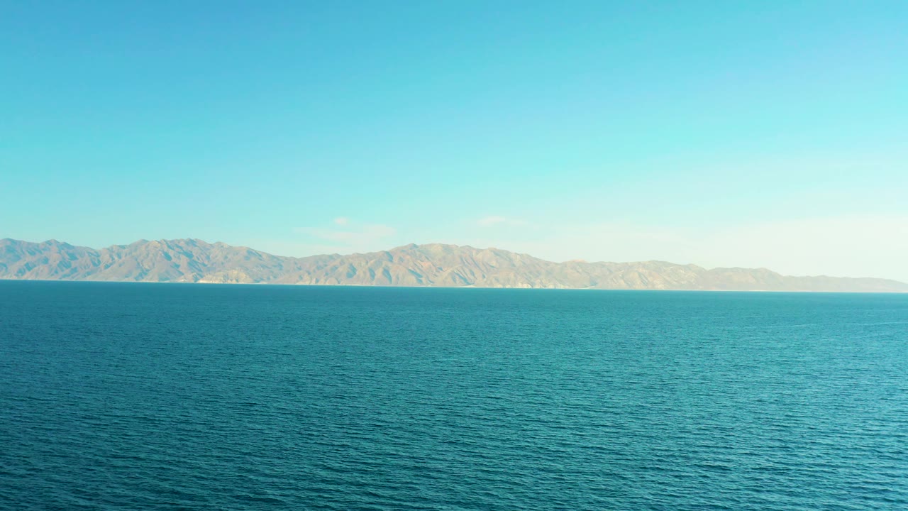 A wide blue sea view in El Sargento La Ventana, Mexico, shows pale mountains across the background and no visible people.