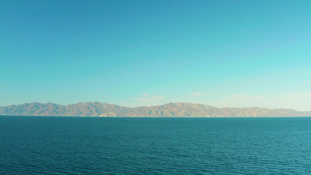 Open sea with pale mountain ridge across the horizon