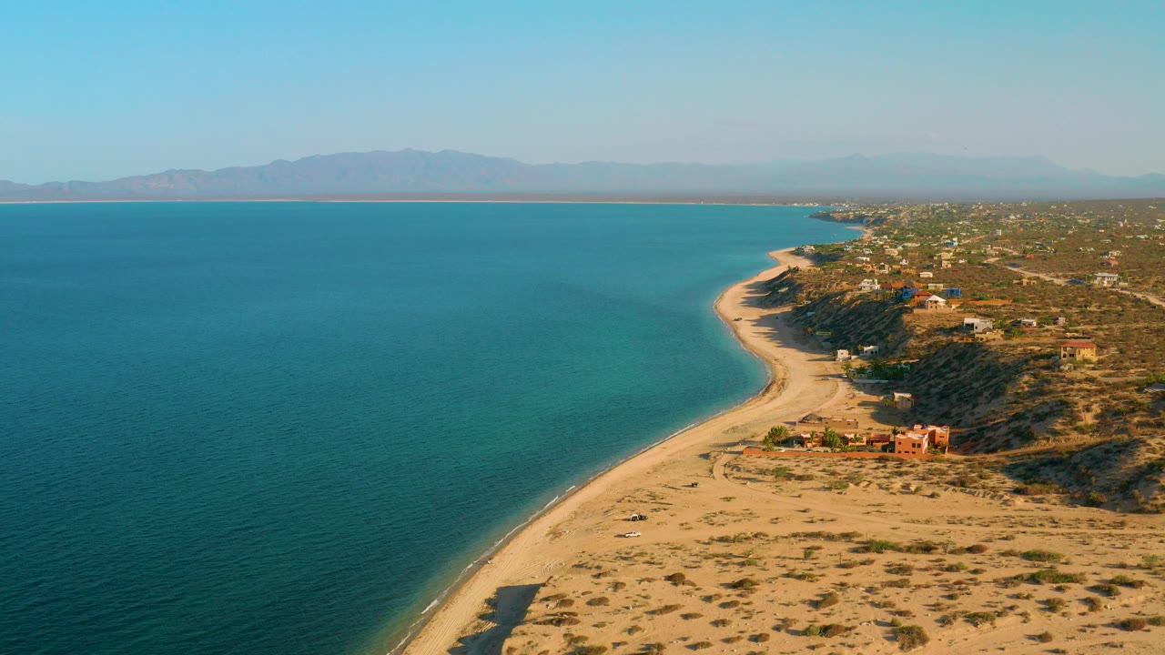 Aerial coastline view with calm sea and sandy point in foreground