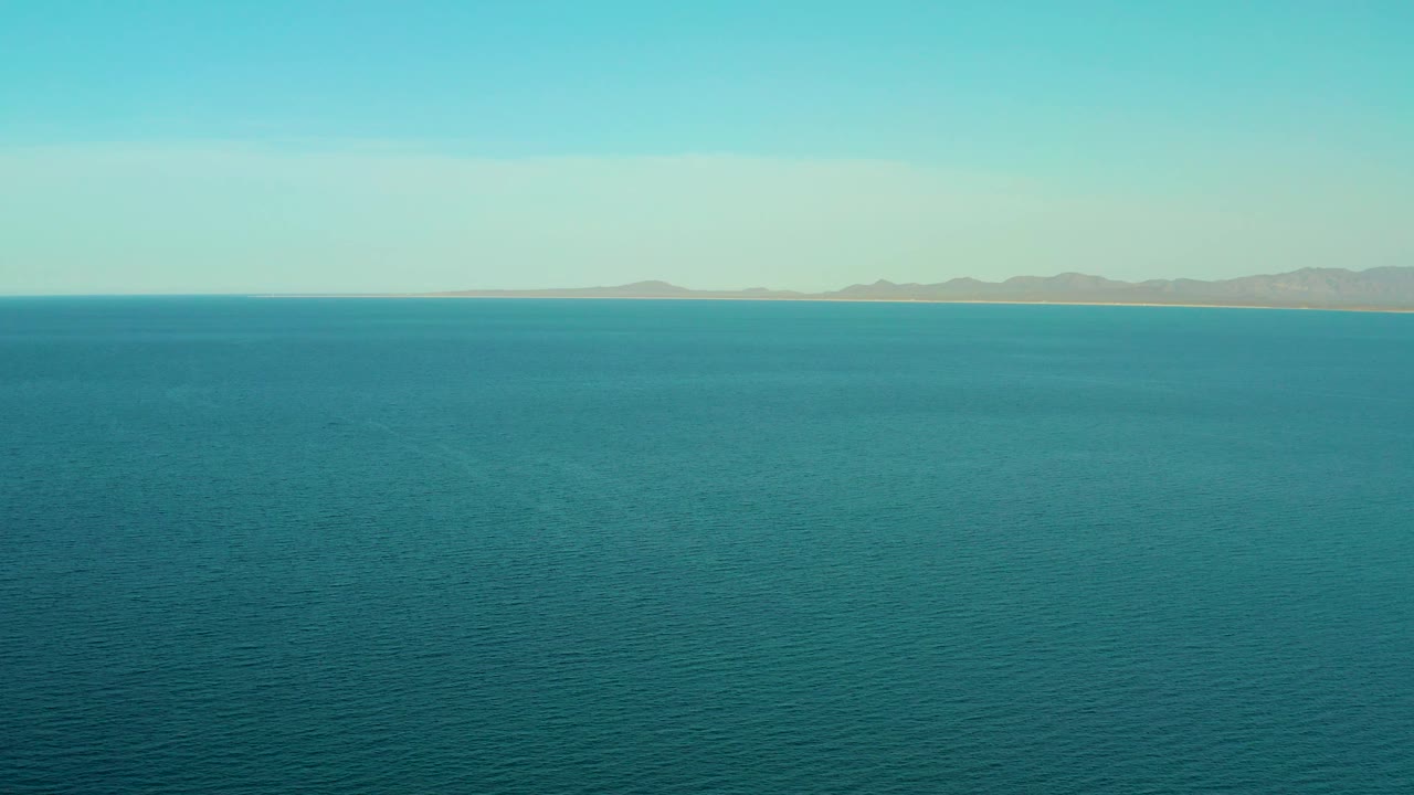 Two seconds into the clip, the ocean remains dominant near El Sargento La Ventana, Mexico, while the far shoreline and low mountains run across the upper frame, no visible people.