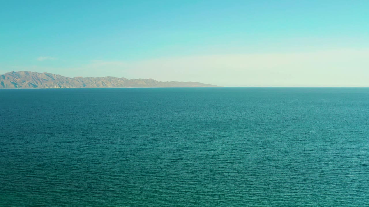 Open ocean surface in El Sargento La Ventana, Mexico, with a distant mountain range across the upper left horizon and no visible people.