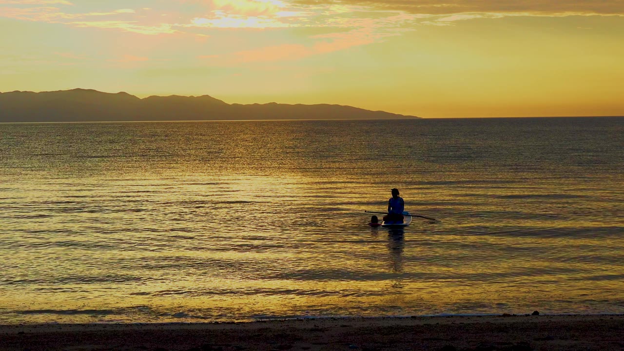 Wide calm water with paddler low in frame