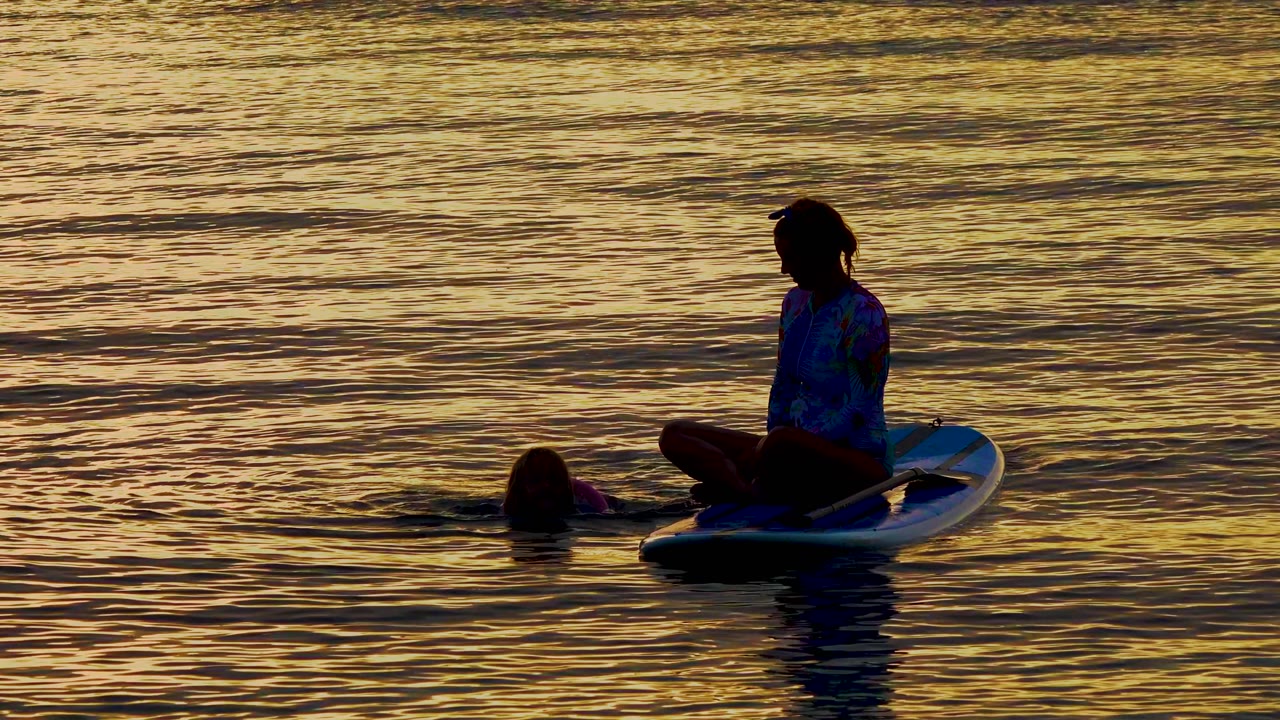 At El Sargento La Ventana, Mexico, the board rider appears farther to the right of frame while the swimmer is separated to the left across darker rippled water.