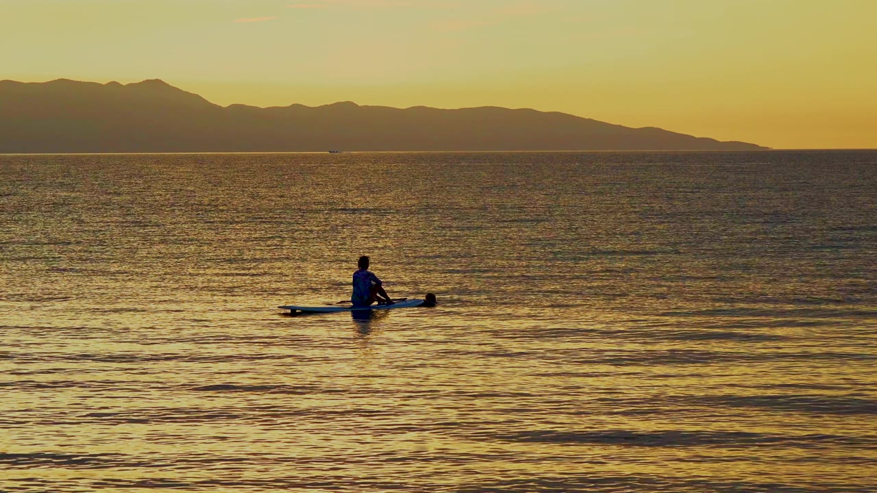 At 0:03 in El Sargento La Ventana, Mexico, the canoeist appears lower against textured yellow water, with the mountain horizon stretching across the background.