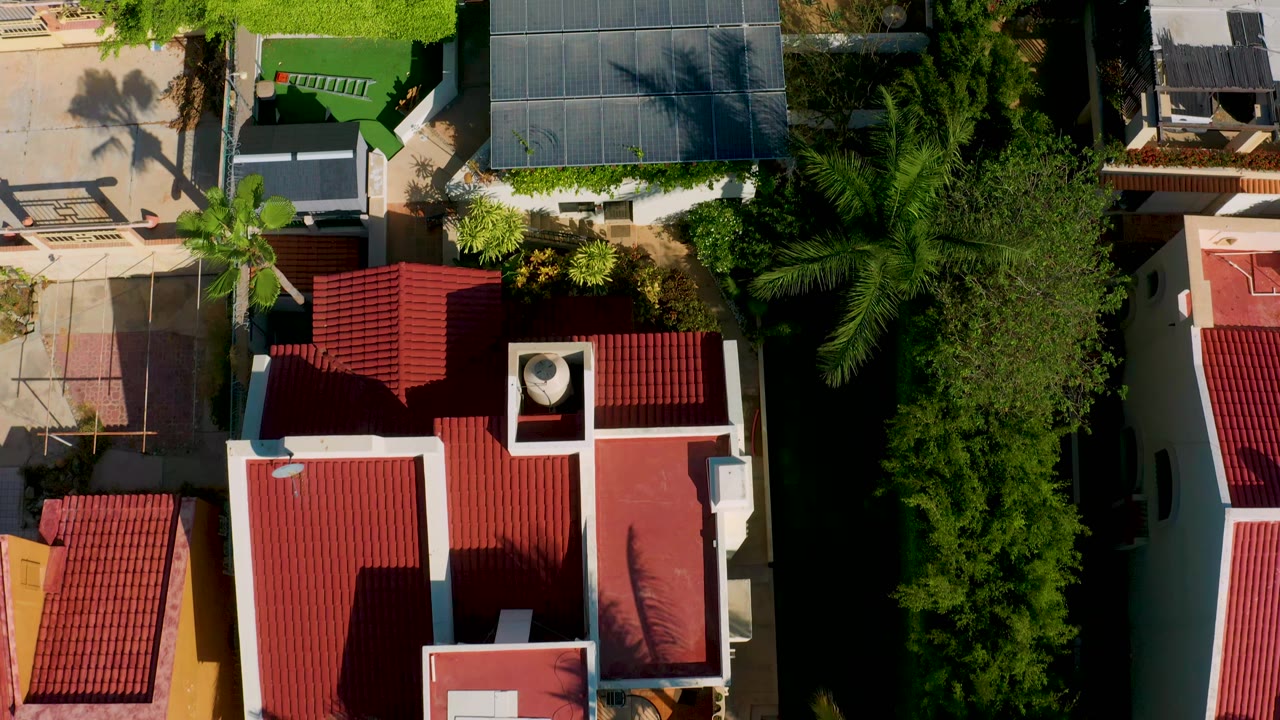 Aerial view of modern houses with red roofs and trees.