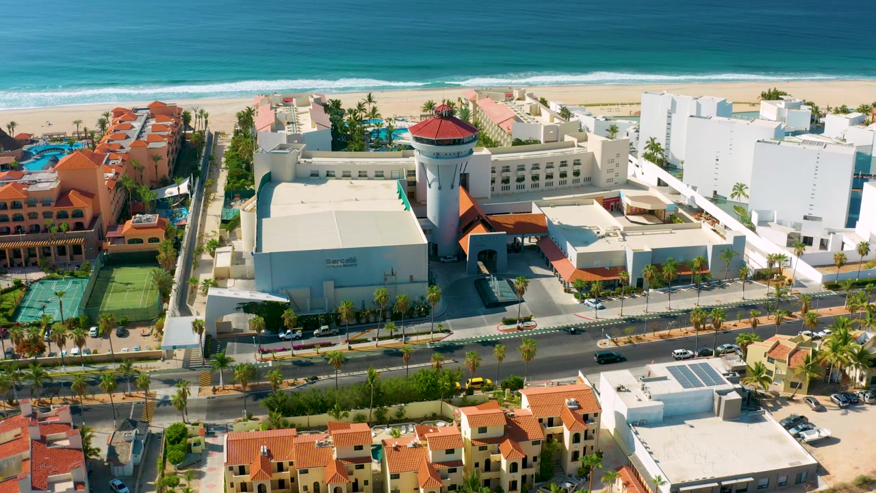 Aerial view of coastal resorts with tennis courts and ocean