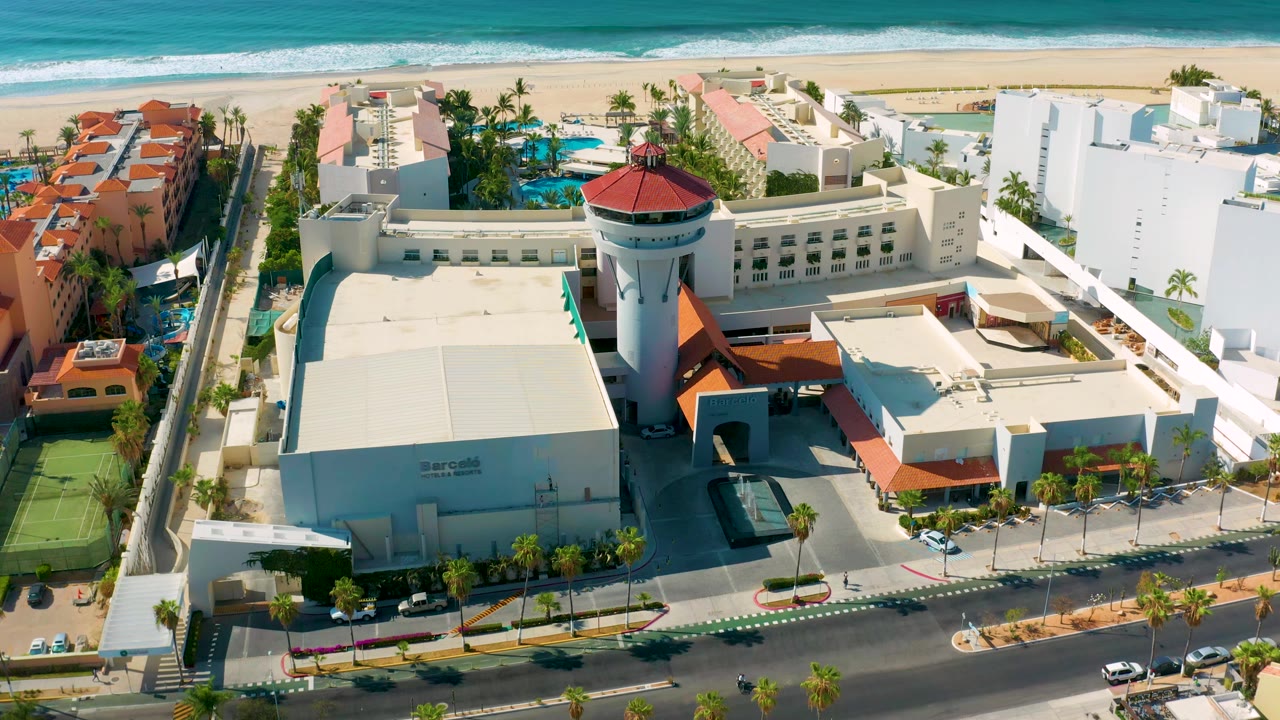 Drone view over hotel roofs, pools, beach, and ocean