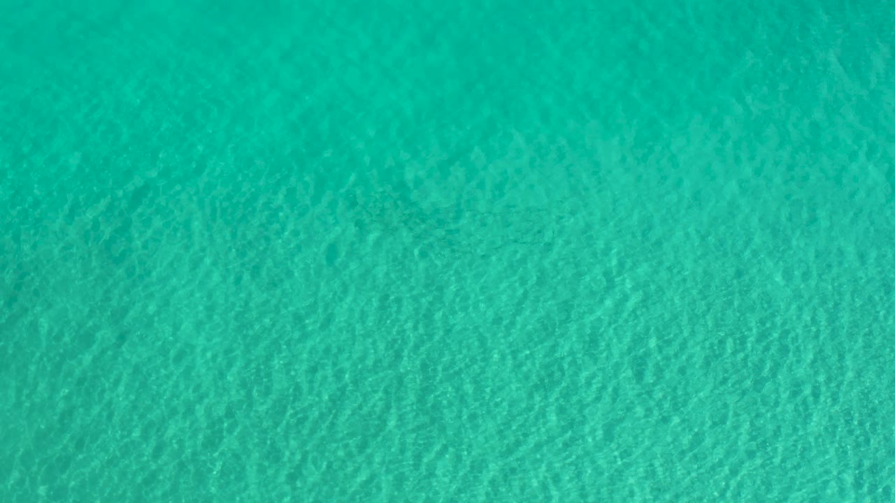 Sunlit turquoise water in Los Cabos Mexico shows small overlapping ripples across the full frame, with no boats, shoreline, or visible people.