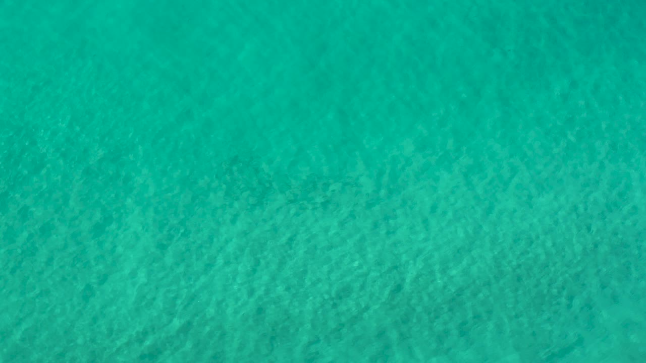 A broad green-blue ocean surface in Los Cabos, Mexico shows fine wave texture across the full frame, with no visible people.
