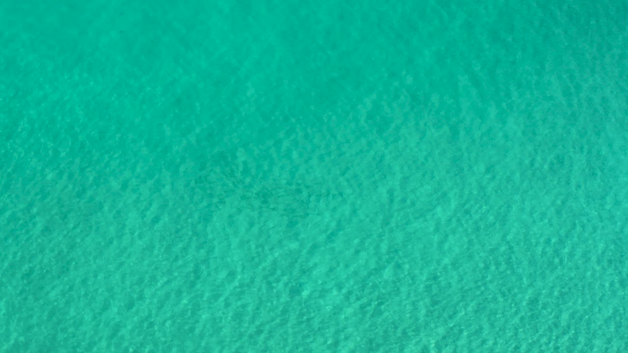 Turquoise green water in Los Cabos fills the opening frame with fine surface ripples and no visible people.