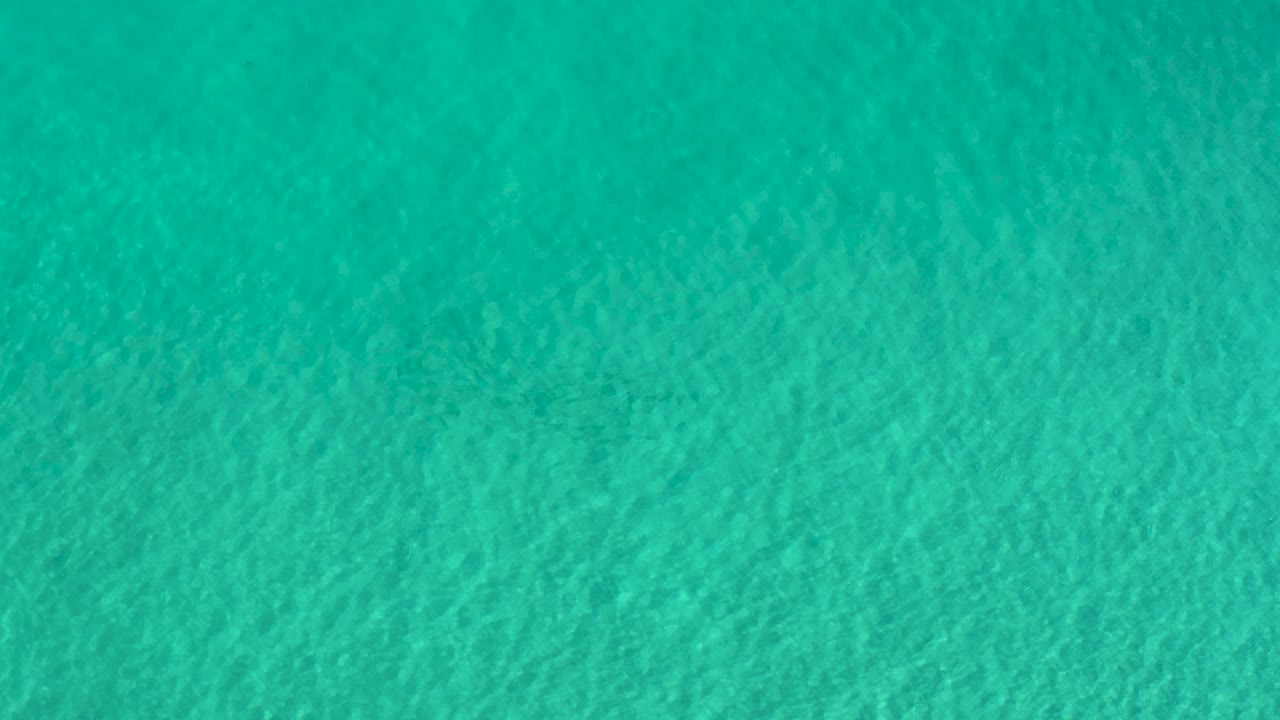 Green ocean water in Los Cabos shows a slightly darker band of ripples across the surface, with no visible people or objects.