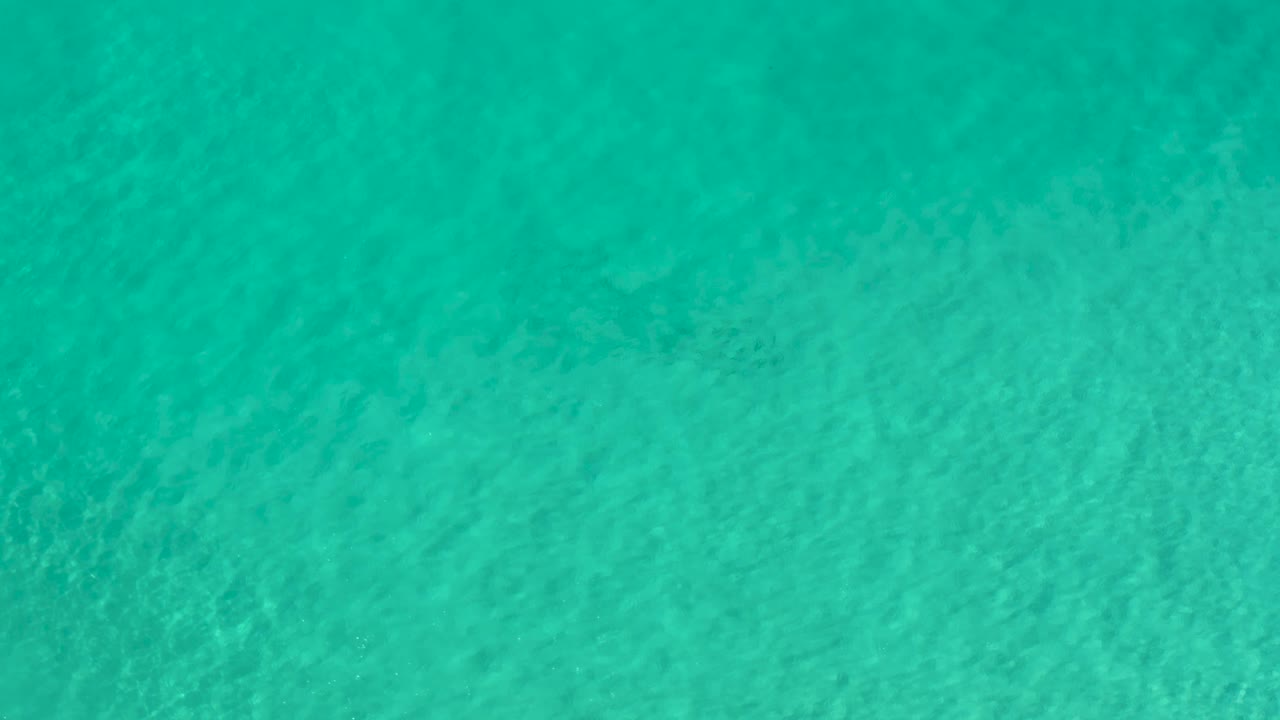 Blue-green ocean surface in Los Cabos, Mexico, fills the frame with subtle wave texture and no visible people one second into the clip.