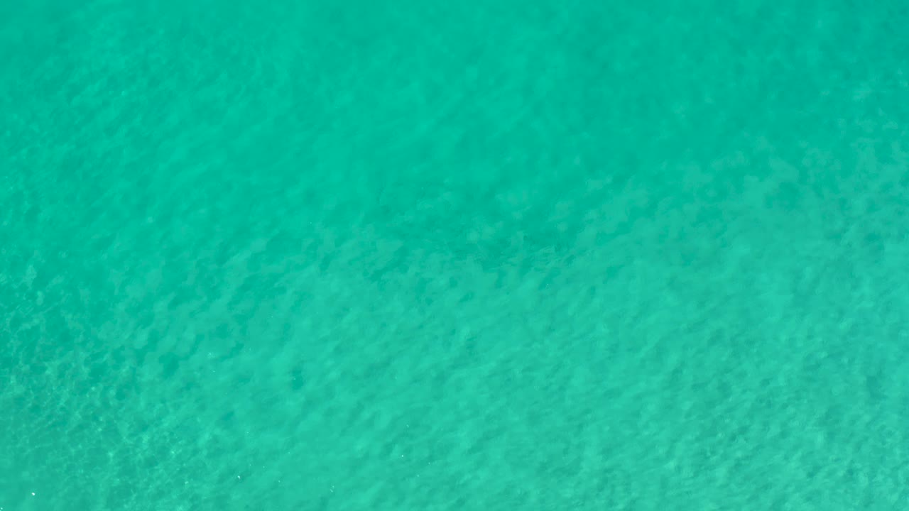 Aqua ocean water in Los Cabos, Mexico, appears slightly softer in texture here, with fine ripples and no visible people.