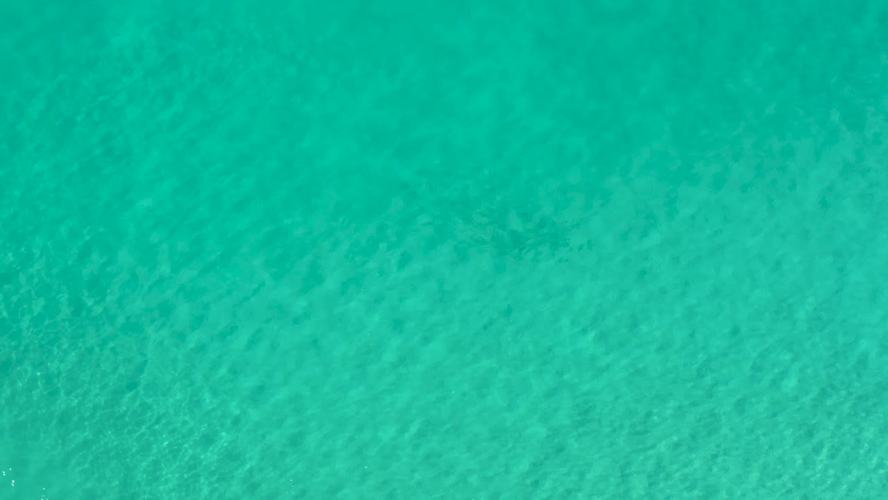 Aerial view of clear turquoise water in Los Cabos, Mexico, showing pale underwater texture and no visible people.