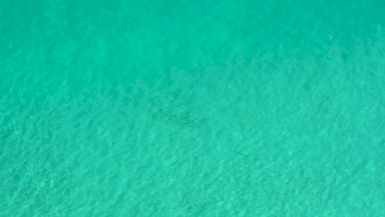 Aqua water surface in Los Cabos fills the first frame with fine ripples and no visible people.