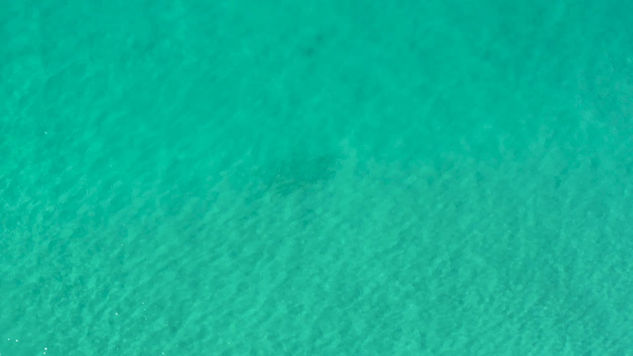 Blue-green ocean water fills the Los Cabos frame, with soft diagonal ripple texture and no visible people or objects.