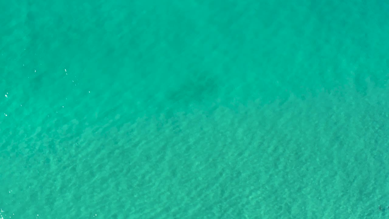 Clear blue-green ocean surface in Los Cabos, Mexico, with soft ripple lines and no visible people.