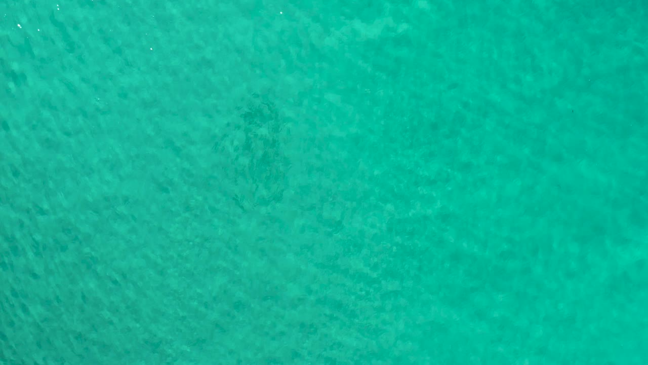 Second frame shows the Los Cabos ocean surface from directly above, with slightly denser ripple texture across the green water and no visible people.