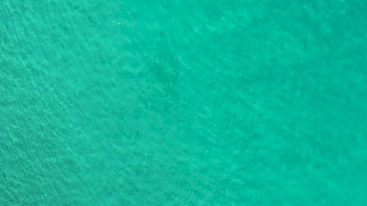 Clear blue-green water with soft ripples.