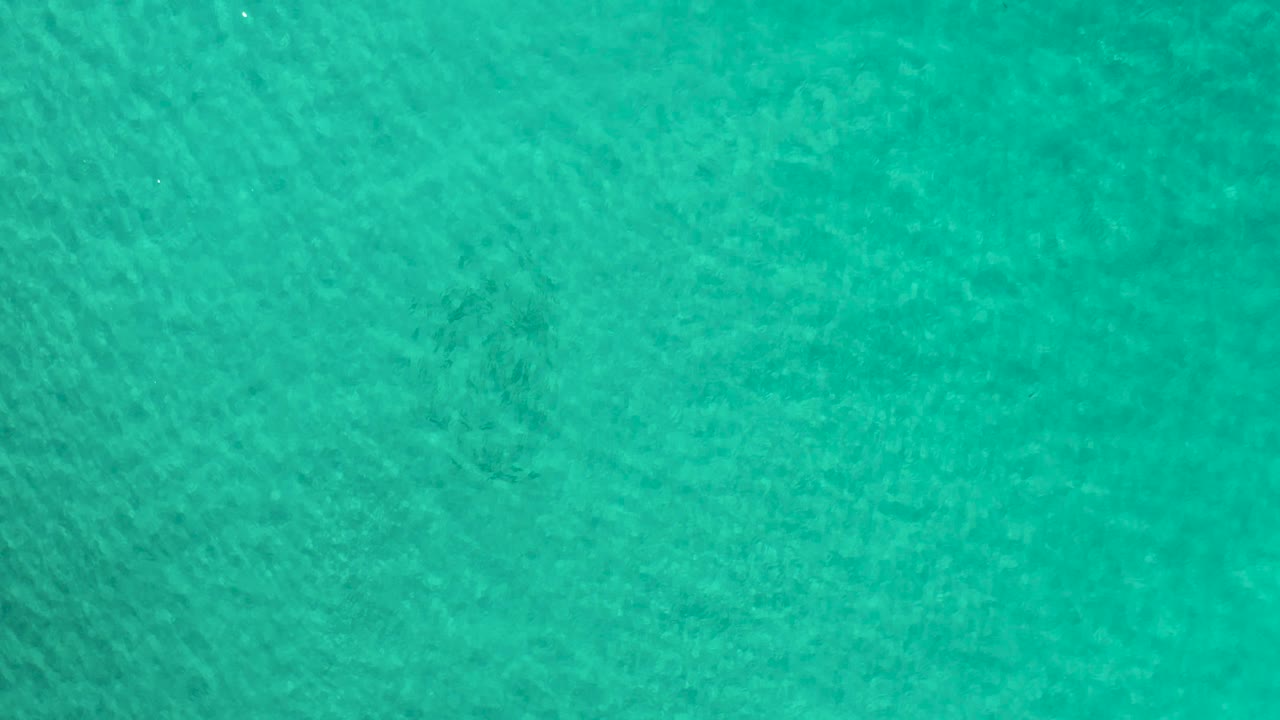 Teal water texture in Los Cabos, Mexico, with soft diagonal ripple lines and no visible people.