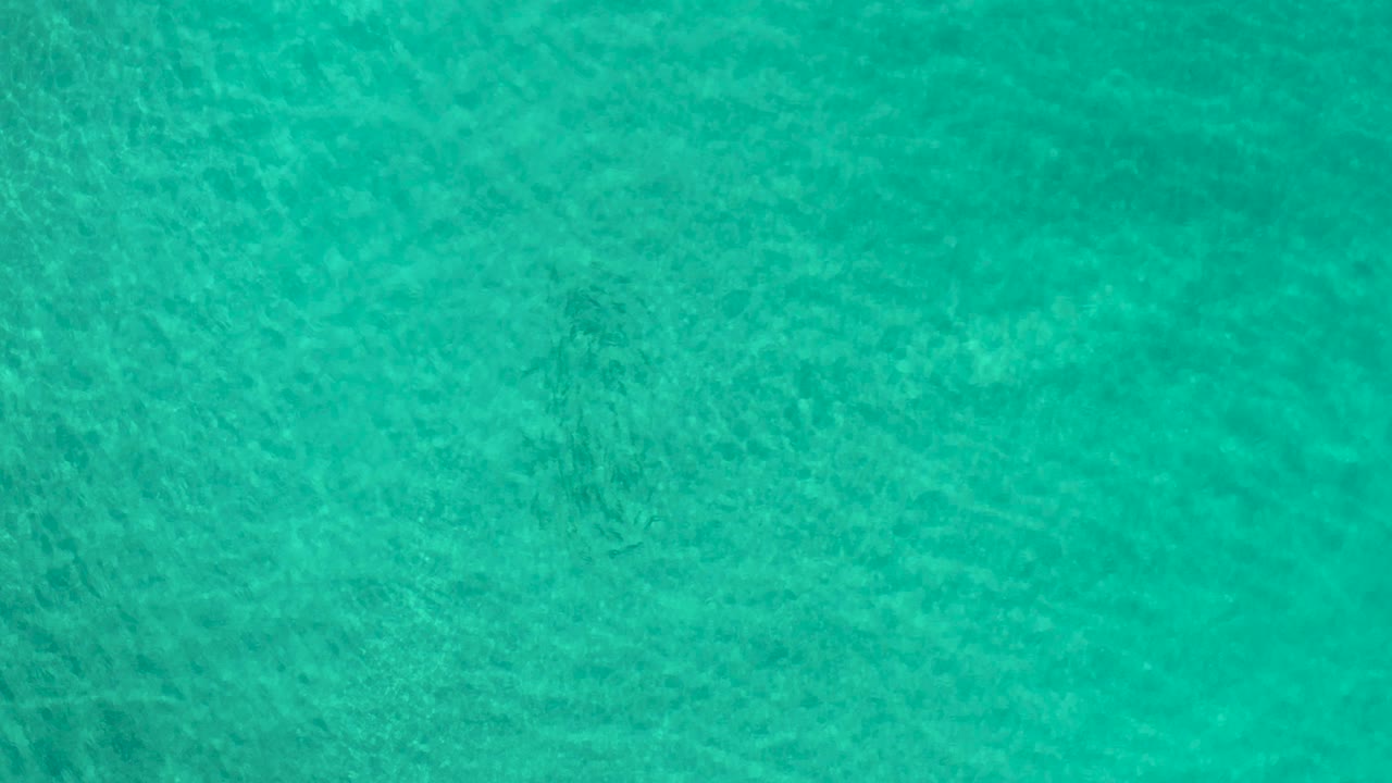 Green ocean ripples with faint darker patches below.