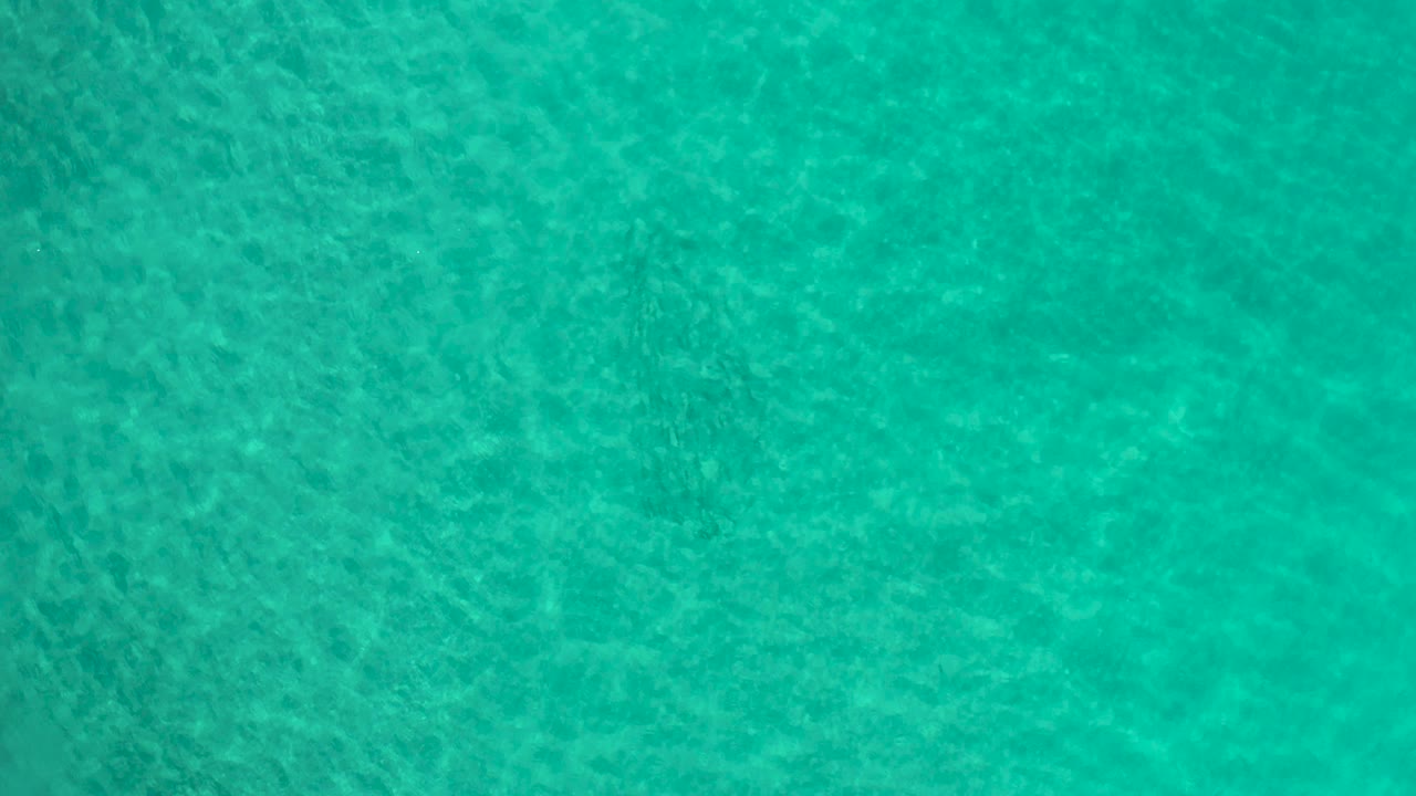 Rippling blue-green water viewed straight down.