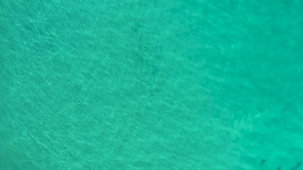 Aqua-green seawater fills the frame in Los Cabos, Mexico, with soft surface texture and no visible people.