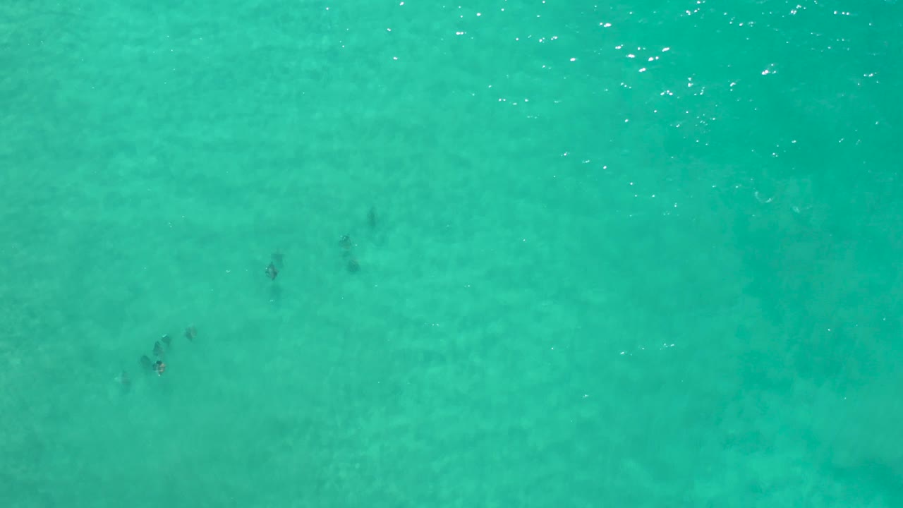 Turquoise sea surface with bright reflections near the upper edge.