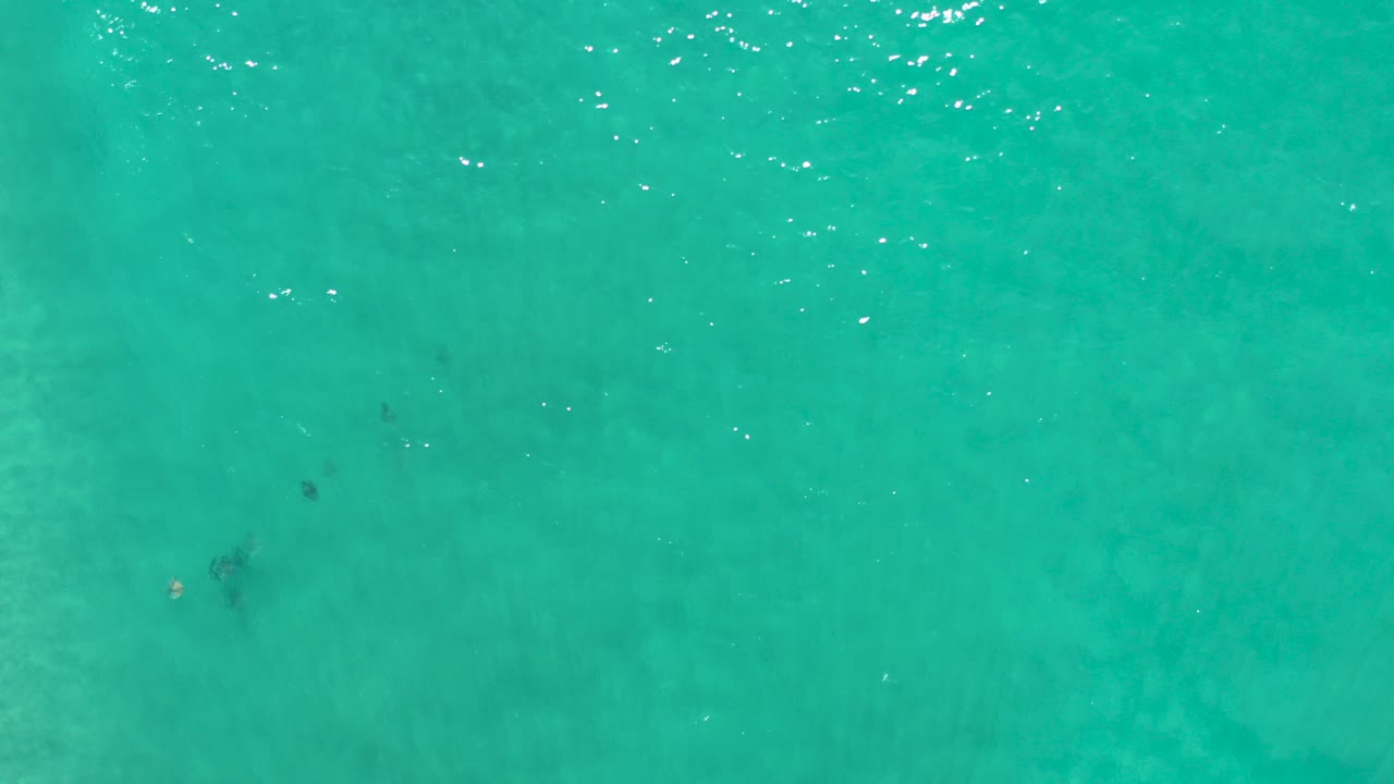 Overhead view of turquoise ocean water in Los Cabos, Mexico, with faint surface shimmer and no visible people.