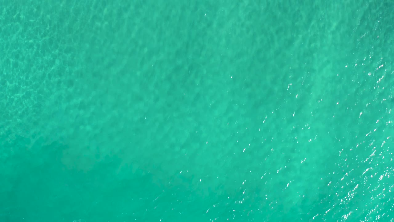 Overhead turquoise ocean surface with small ripples.