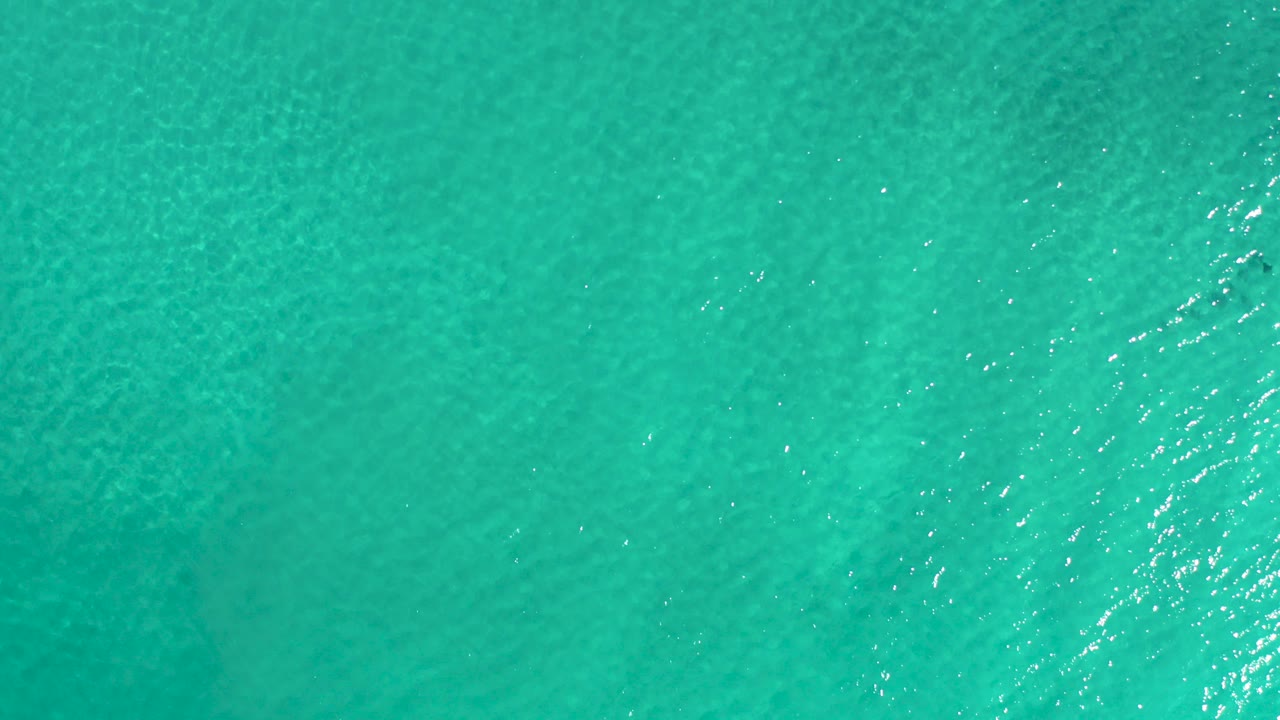 Turquoise ocean water seen from above with small ripples.