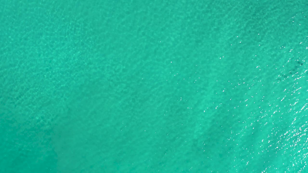 Open turquoise sea with fine texture and faint darker areas.