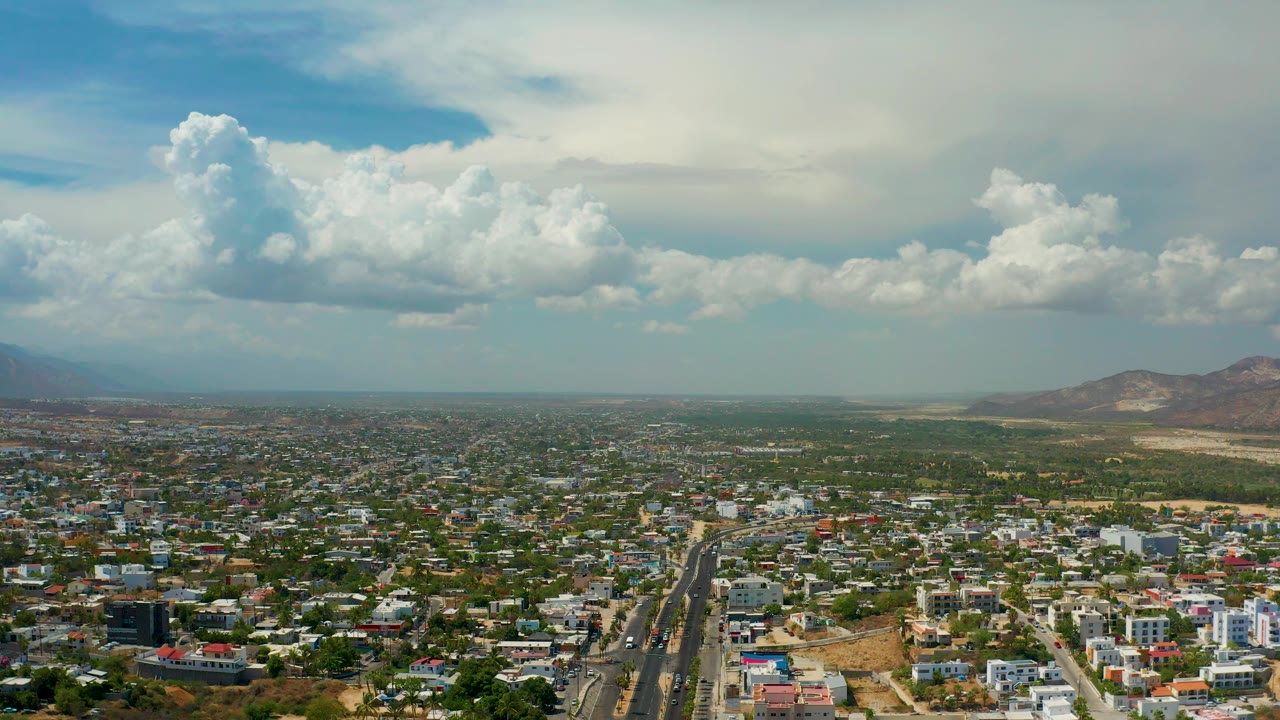 Aerial urban landscape with road, homes, and mountains