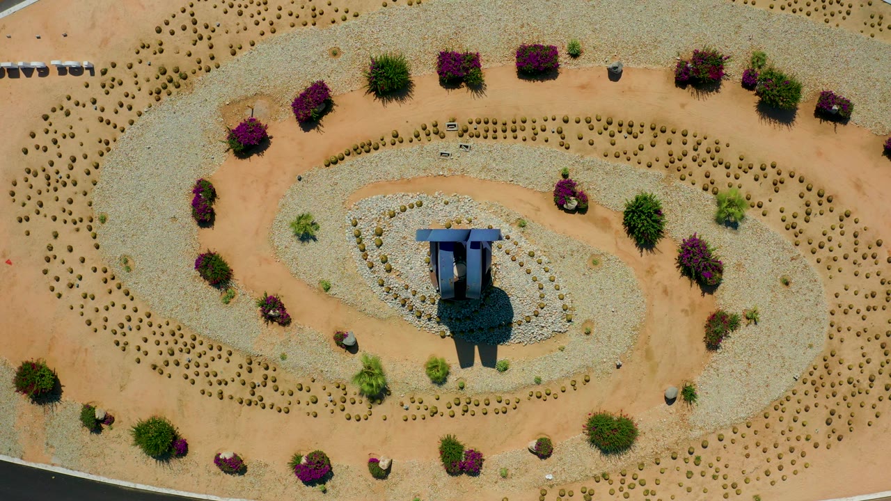 Desert garden seen from directly above with curved beds and shrubs.