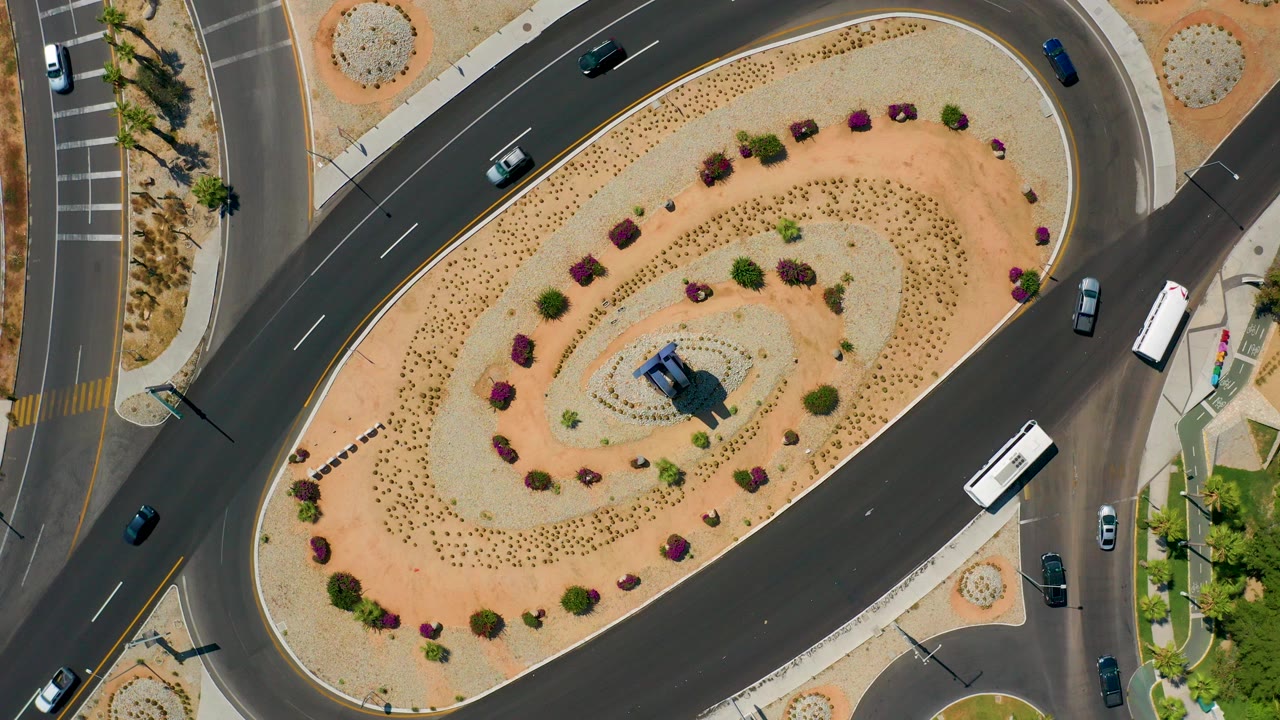 Overhead traffic loop with cars around a landscaped center island.