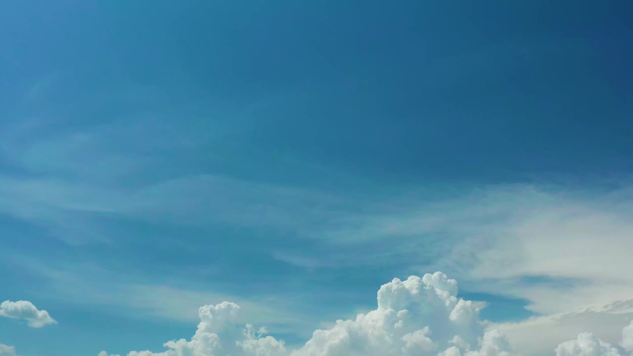 Second frame of the Los Cabos sky clip, showing a darker blue upper sky, soft midlevel cloud bands, and no visible people.