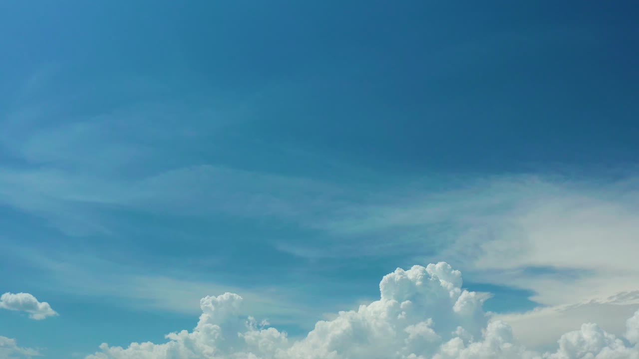 A Los Cabos sky frame with a broad blue upper field and a cluster of white clouds rising from the lower right, with no visible people.