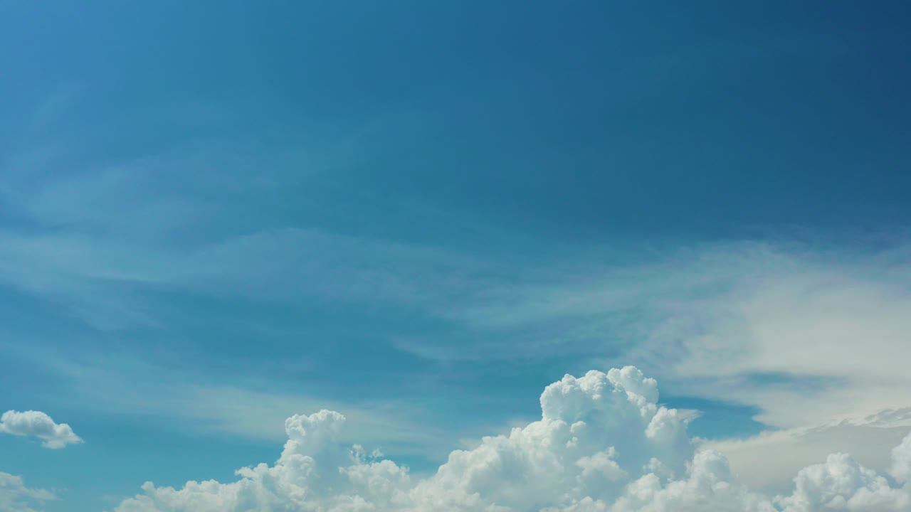 Mid-clip frame showing soft white cloud forms across the bottom of a saturated blue Los Cabos sky, with no visible people or objects.