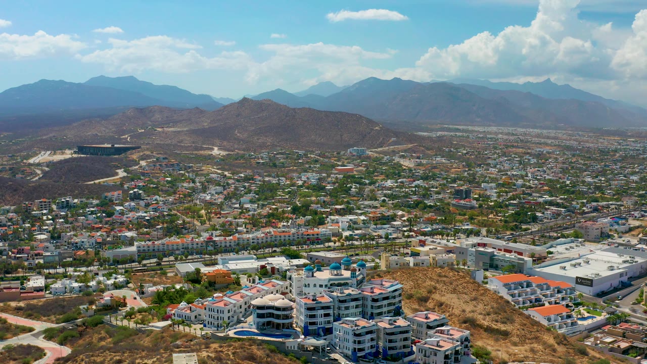 City and desert hills seen from above with mountains in haze