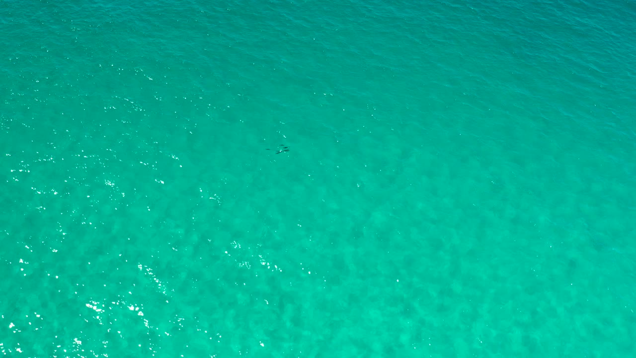 Open turquoise ocean with brighter glints near the lower left